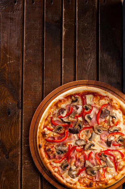 Pizza na mesa de madeira com ingredientes de pizza
  - Foto, Imagem