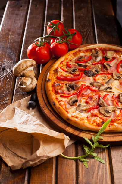 Pizza on wooden desk with pizza ingredients  - Foto, afbeelding