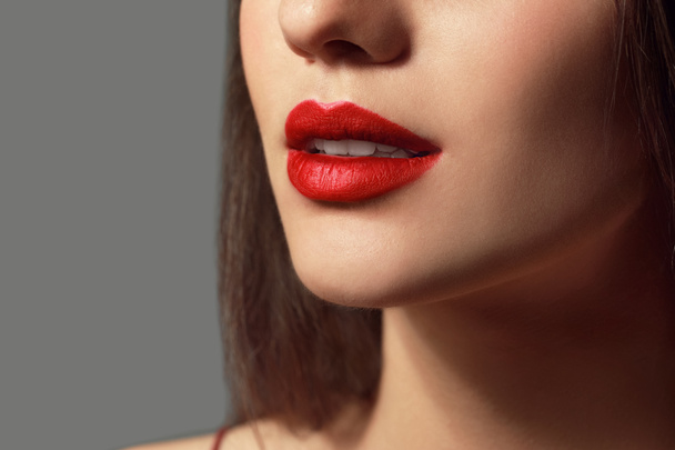 Beautiful young woman with bright lipstick on grey background, closeup - 写真・画像