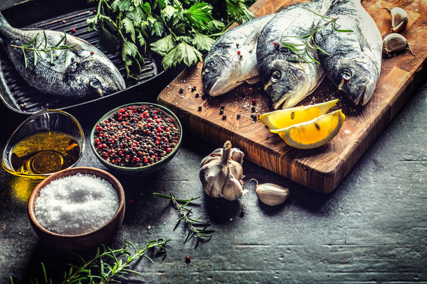 Mediterranean fish bream with spices salt herbs garlic and lemon. Healthy seafood. Concept of healthy sea food - 写真・画像