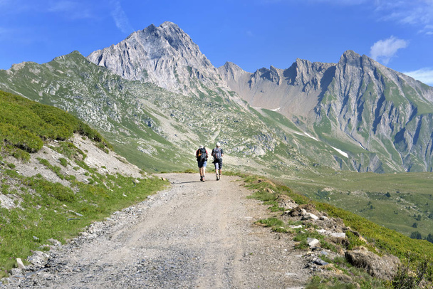 beautiful mountain landscape with hikers walking on a hiking trail - Фото, зображення