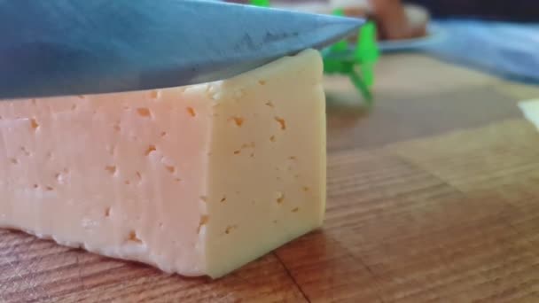 木製の背景にナイフでチーズをカット, スローモーション - 映像、動画