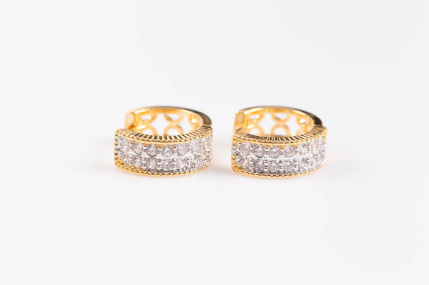 Ohrringe. Goldene Ohrringe mit Diamanten auf weißem Hintergrund. - Foto, Bild