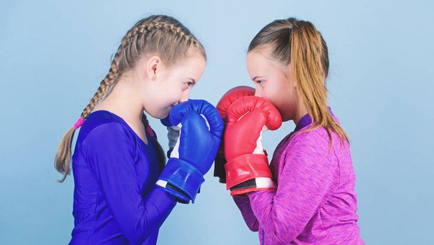 Female friendship. Girls in boxing sport. Boxer children in boxing gloves. Girls cute boxers on blue background. Friendship as battle and competition. Pass boxing challenge. Test for fortitude - Valokuva, kuva