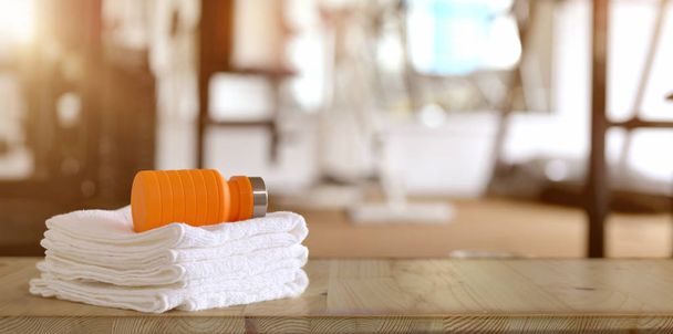Рушники та апельсинова спортивна пляшка з тренажерним фоном
 - Фото, зображення