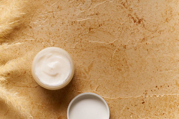 Spa beauty skin care mock-up on travertine background with cream in small container. Top view  - Valokuva, kuva