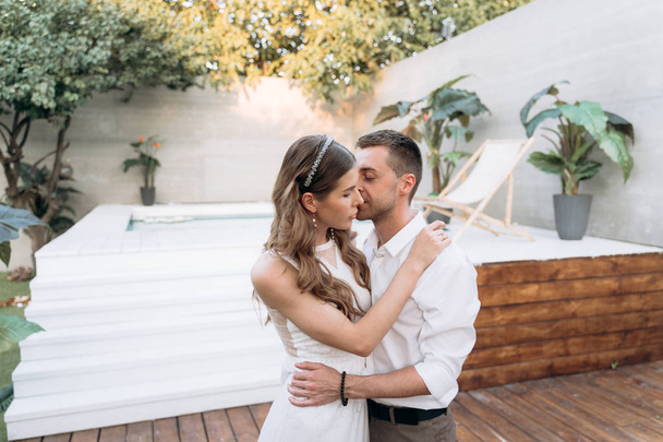 shot of couple  embracing on the yard with swimming pool on the background - Foto, Bild