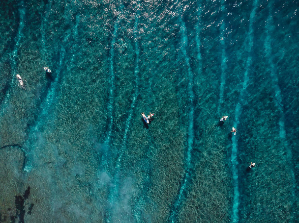 Вид с воздуха на серферов и волну в голубом чистом океане. Вид сверху
 - Фото, изображение