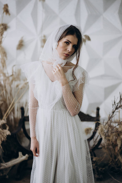cheerful lady in white dress and stylish shawl standing in the studio   - Valokuva, kuva