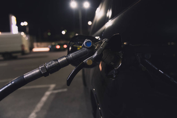 Cisternové vozy s plynovým olejem na benzinové stanici. Černé auto v noci dostává palivo. Samoobslužný. - Fotografie, Obrázek