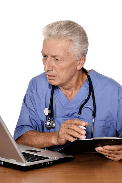 ältere Ärztin mit Laptop auf weißem Hintergrund - Foto, Bild