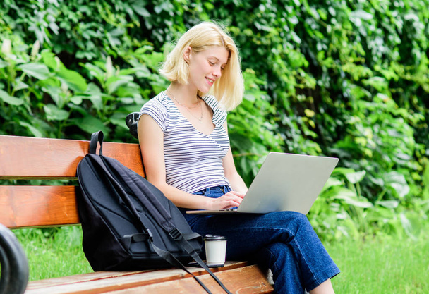 Modern student life. Regular student. Surfing internet. Girl adorable student with laptop coffee cup and backpack sit bench park. Woman student work with notebook. Learn study explore. Study outdoors - Fotó, kép