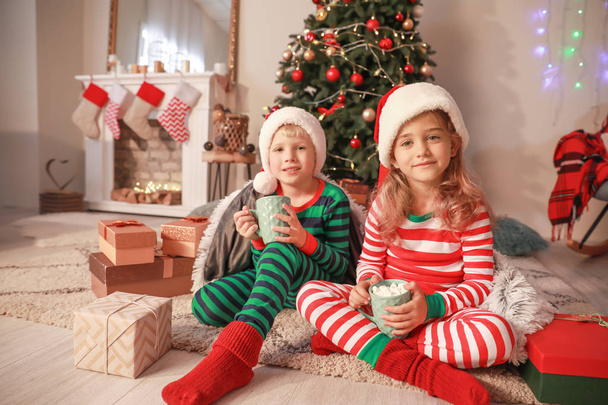 Crianças pequenas bonitos beber chocolate quente na véspera de Natal em casa
 - Foto, Imagem