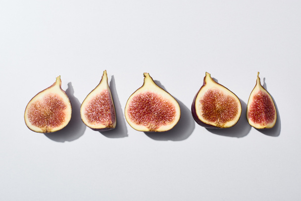 flat lay with ripe cut delicious figs on white background - 写真・画像