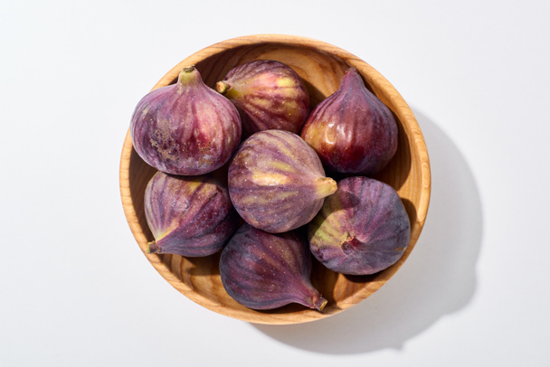 top view of ripe whole delicious figs in wooden bowl on white background - Photo, Image