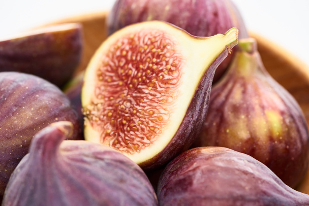 close up view of ripe delicious fig half in wooden bowl on white background - Fotografie, Obrázek