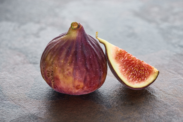 ripe whole and cut delicious figs on stone background - Foto, imagen