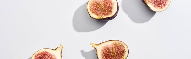 panoramic shot of ripe cut delicious figs on white background - Foto, Imagen
