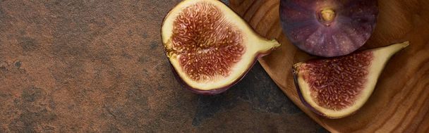 panoramic shot of ripe delicious figs on wooden board on stone background - Photo, Image