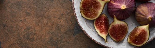 panoramic shot of ripe whole and cut delicious figs on plate on stone background - Φωτογραφία, εικόνα
