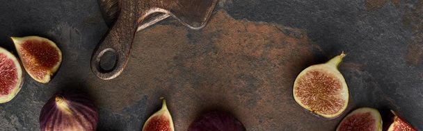 panoramic shot of ripe figs near wooden cutting board on stone background - Zdjęcie, obraz