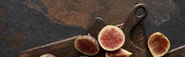top view of tasty figs and wooden cutting boards on stone background, panoramic shot - 写真・画像