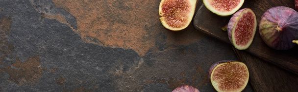 top view of fresh figs and wooden cutting boards on stone background, panoramic shot - Foto, imagen