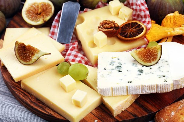 Πιατέλα τυριών με διαφορετικά τυριά και σταφύλια και σύκα και καρύδια - Φωτογραφία, εικόνα
