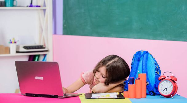 homeschooling concept. Good morning. back to school. Online education. study online. Lesson alarm. sleepy small girl pupil with computer. Use new technology. girl in class with clock wait for day end - Photo, Image