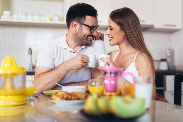 Szczęśliwa para ciesząca się razem śniadaniem w domu. - Zdjęcie, obraz