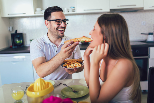 Happy couple enjoying breakfast time together at home. - Foto, Imagen