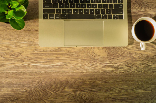 (Światło rano) Flay lay, widok z góry biurka biurowego z laptopem i białą filiżanką kawy na drewnianym stole w domu lub biurze. z przestrzenią kopiowania. - Zdjęcie, obraz
