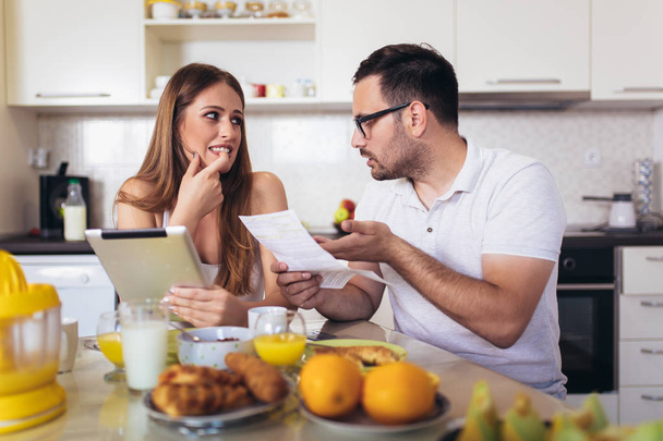 Ehepaar diskutiert in der Küche über Haushalt. - Foto, Bild