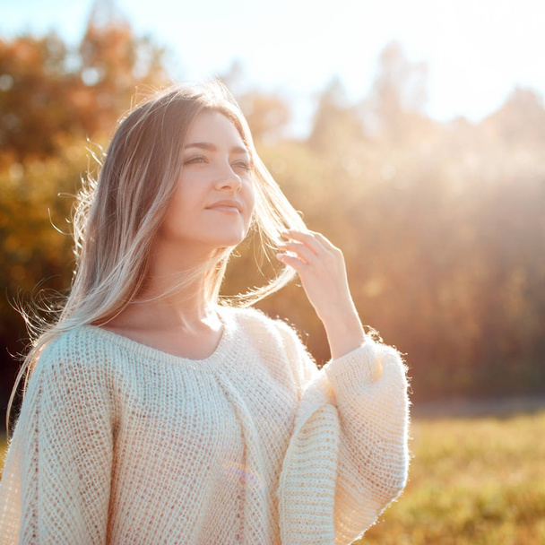 Pretty girl posing on camera and enjoying sunny autumn day. - Foto, Imagen