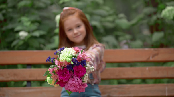 чарівна усміхнена дитина з квітами на лавці
 - Кадри, відео