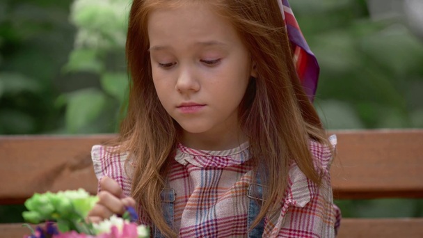 чарівна вдумлива і усміхнена дитина з квітами в парку
 - Кадри, відео
