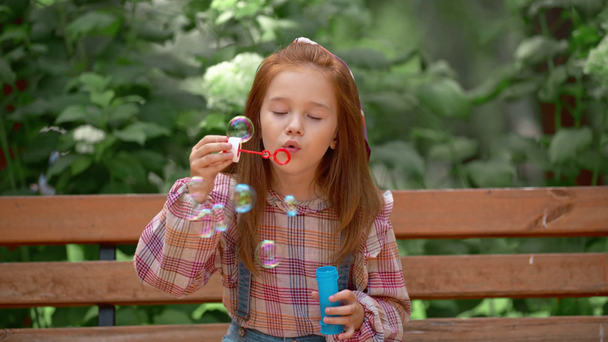 чарівна щаслива дитина дме мильні бульбашки в парку
 - Кадри, відео