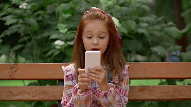 dziecko biorę selfie na smartfonie i stwarzając w parku - Materiał filmowy, wideo