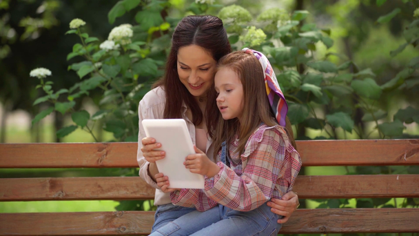 matka i córka mający wideo rozmowa na cyfrowy tablet w Park - Materiał filmowy, wideo