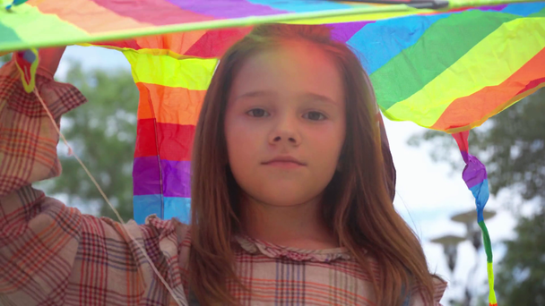 cute child walking with rainbow kite in park - Footage, Video