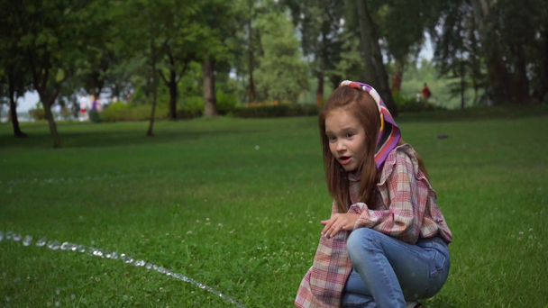 criança feliz brincando com o fluxo de água no gramado verde
 - Filmagem, Vídeo