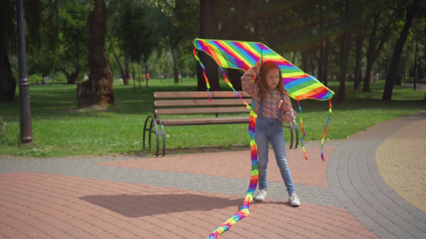 Nettes glückliches Kind läuft mit Drachen im Park - Filmmaterial, Video