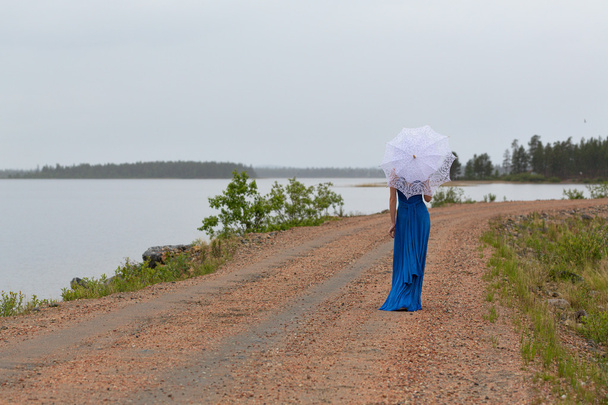 Slim girl in a dress with an umbrella in a forest - Foto, afbeelding
