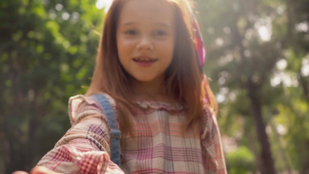 cute smiling child in sunlight in green park - Video, Çekim