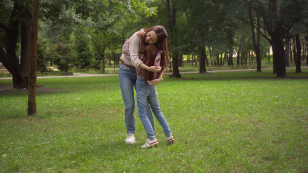 moeder en dochter omarmen in park - Video