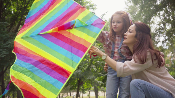 parkta gökkuşağı renkli uçurtma ile anne ve kızı - Video, Çekim