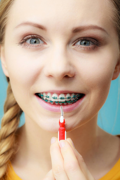 Woman with teeth braces using interdental brush - Фото, изображение