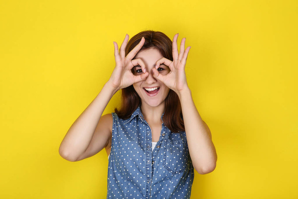 Young woman in stylish clothing on yellow background - Foto, afbeelding