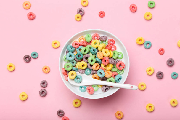 Colorful corn rings in bowl with milk and spoon on pink backgrou - 写真・画像