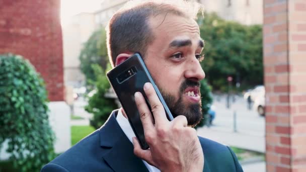 Businessman on the phone in the city with the sun behind his head - Video